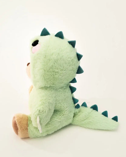 Plüss maci zöld dinoszaurusz jelmezben, ülve, oldalnézetben, játék ajándék gyerekeknek