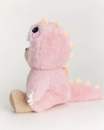 Rózsaszín plüss maci dinoszaurusz jelmezben, ülő pozícióban, fehér háttéren